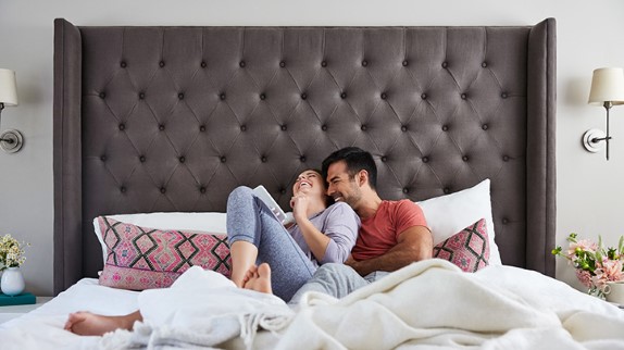 happy couple in bed, early signs of pregnancy before a missed period