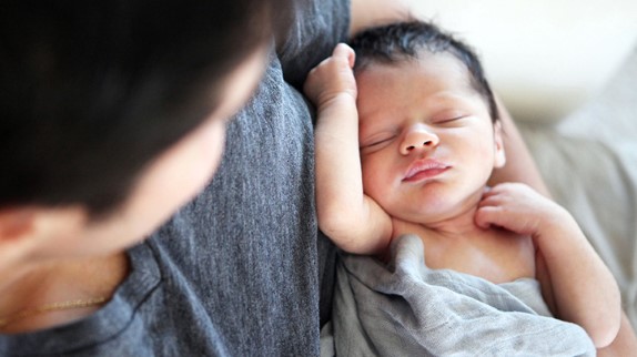 how much sleep do babies need, tiny baby sleeping in father's arms