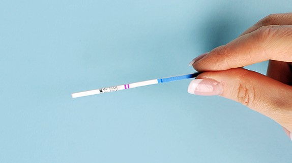 ovulation test strips, hand holding ovulation test strip